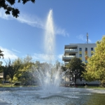 Sprudelnde Wasserfontäne des erneuerten Lions-Brunnens am Breiten Weg in Halberstadt vor modernem Gebäude